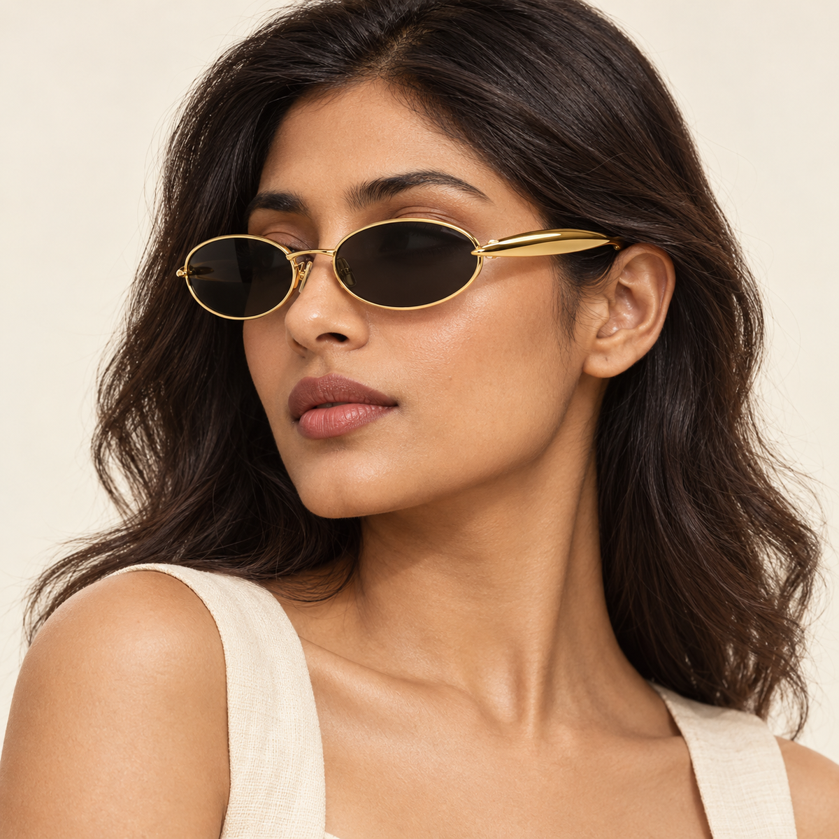 Woman wearing Bottega Veneta BV1386S 001 gold oval sunglasses